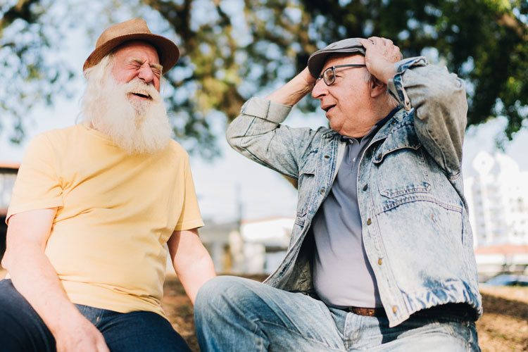 Zwei sich gegenüber sitzende und lachende Männer